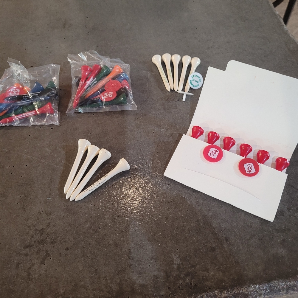 Assortment of advertising golf Tees and golf ball markers.  New